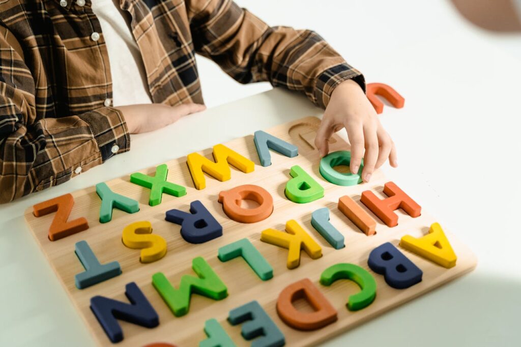 Child playing with colorful wooden alphabet blocks, building language and cognitive skills